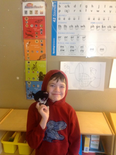 Aaron finished HOP Master Reader! The poster behind him shows his progress.